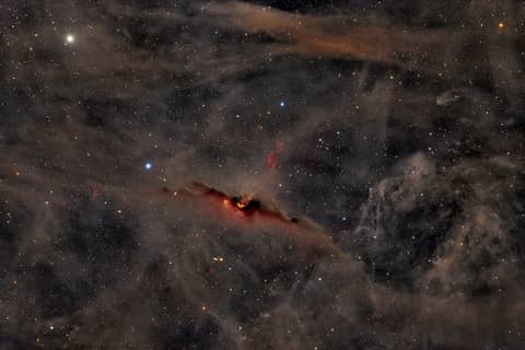 The Red Glow of the Cosmic Bat Nebula