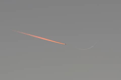 Jet Approaching a Crescent Moon