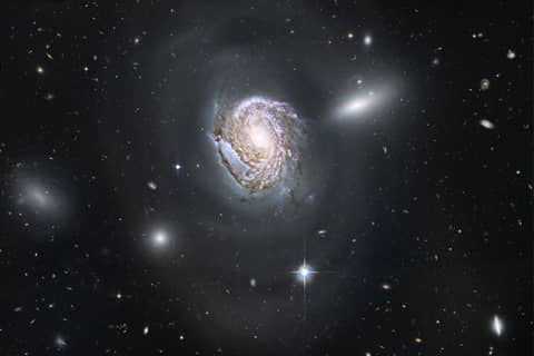 NGC 4911: Spiral Diving into a Dense Cluster